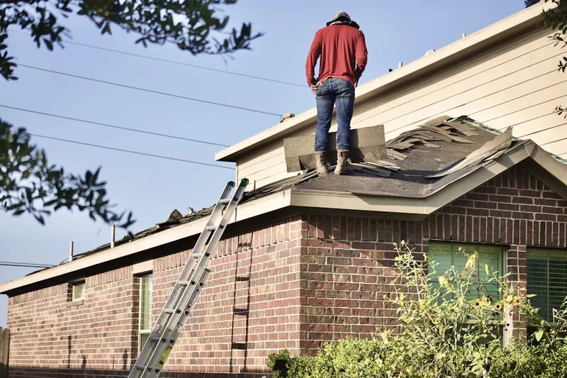 Professional roofer working on a residential roof in Saybrook Manor